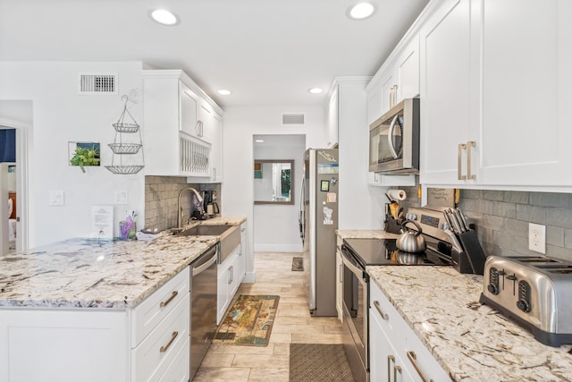 kitchen featuring white cabinets, decorative backsplash, sink, and stainless steel appliances