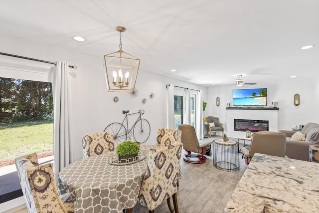 dining room featuring ceiling fan with notable chandelier and light hardwood / wood-style floors