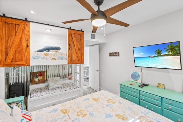 bedroom featuring a barn door and ceiling fan