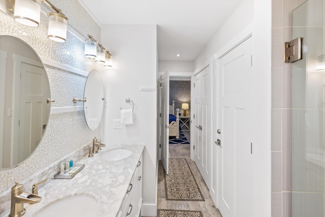 bathroom with wood-type flooring, vanity, and walk in shower