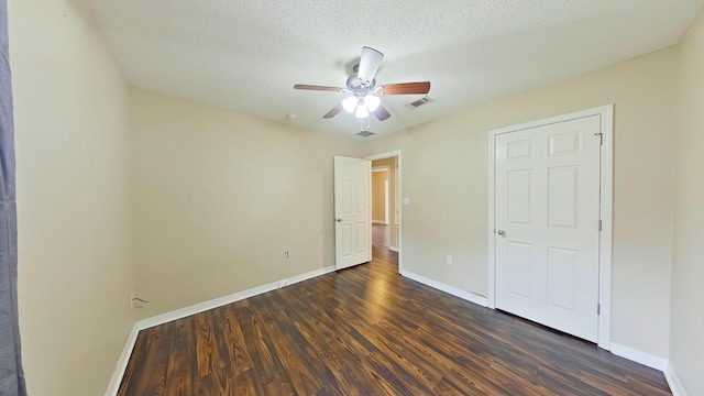 unfurnished bedroom featuring a textured ceiling, ceiling fan, and dark hardwood / wood-style floors