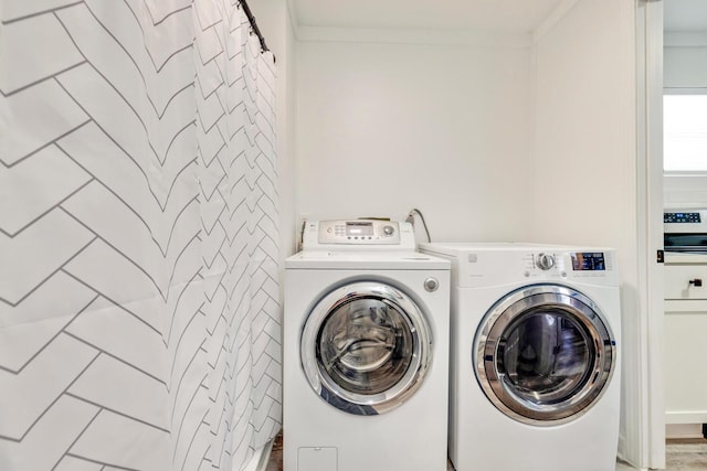 washroom featuring washer and clothes dryer and ornamental molding