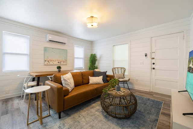 living room featuring a wall unit AC, dark hardwood / wood-style flooring, and plenty of natural light