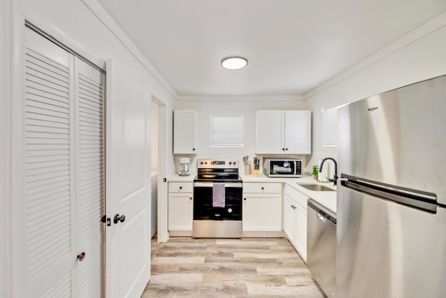 kitchen featuring crown molding, sink, white cabinets, and appliances with stainless steel finishes