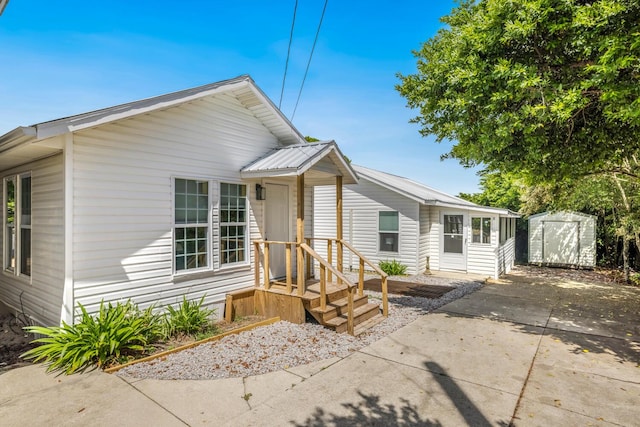 view of front of home featuring a patio area and a storage unit