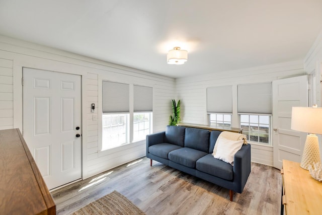 living room featuring hardwood / wood-style floors, a healthy amount of sunlight, and wood walls