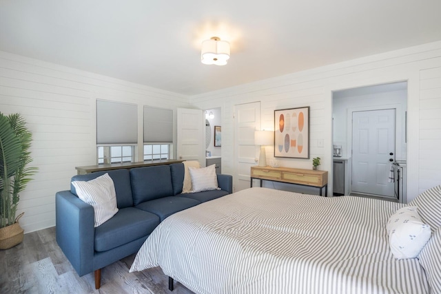 bedroom featuring wood walls and dark wood-type flooring