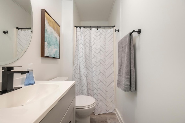 bathroom with wood-type flooring, vanity, and toilet