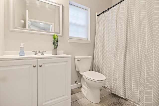 bathroom with a shower with shower curtain, vanity, and toilet