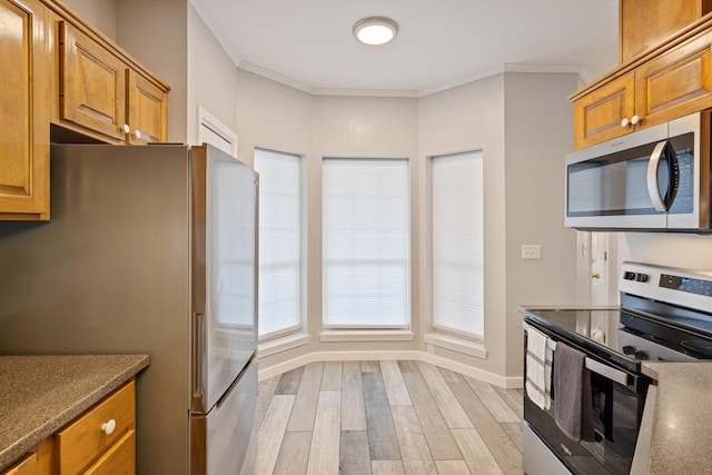 kitchen featuring appliances with stainless steel finishes, light hardwood / wood-style floors, and ornamental molding