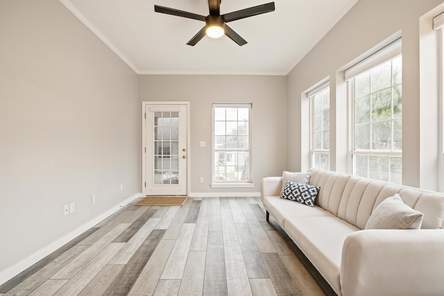 living room with ceiling fan, ornamental molding, and light hardwood / wood-style flooring