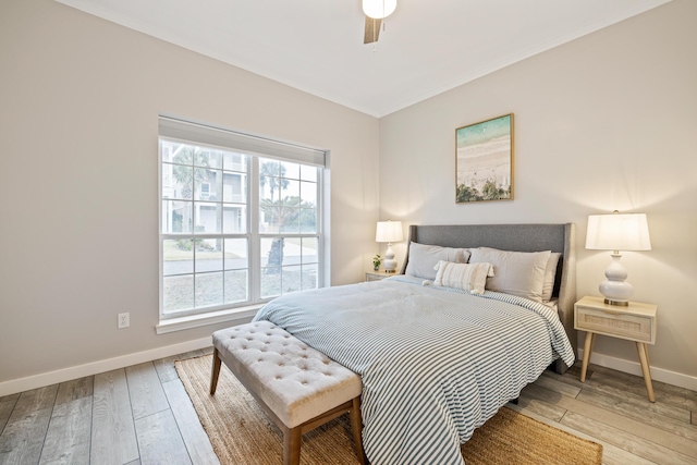 bedroom with multiple windows, ceiling fan, and light wood-type flooring