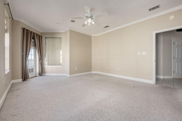 spare room with ceiling fan, crown molding, and light colored carpet