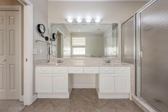 bathroom with tile patterned floors, vanity, a shower with door, and crown molding