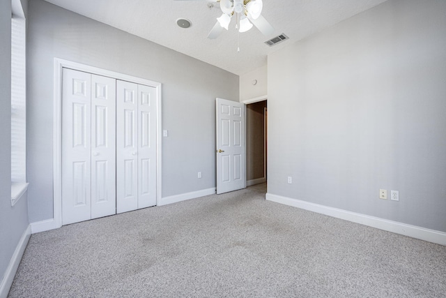 unfurnished bedroom with ceiling fan, a closet, and light carpet