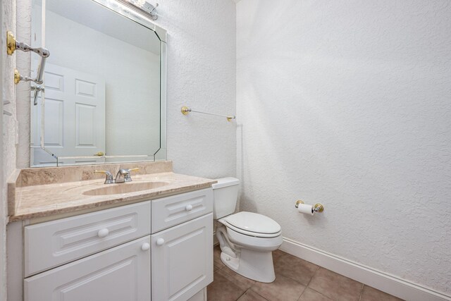 bathroom with tile patterned flooring, vanity, and toilet