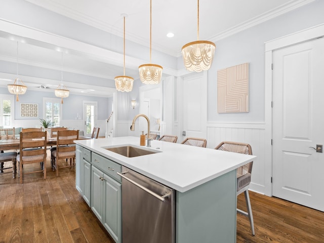 kitchen with a kitchen bar, sink, pendant lighting, dishwasher, and an island with sink