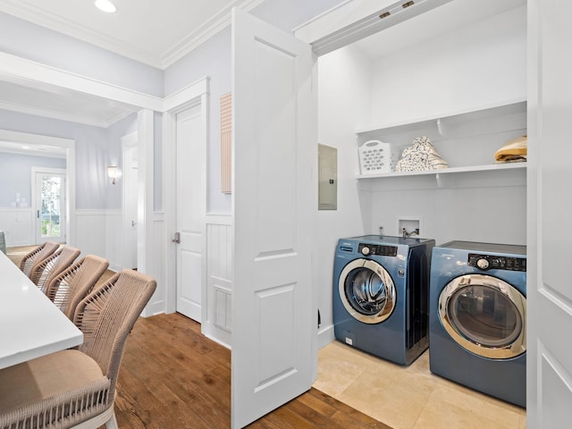 washroom featuring electric panel, light tile patterned floors, washer and dryer, and ornamental molding