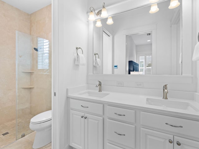 bathroom featuring tile patterned flooring, a shower with door, vanity, and toilet