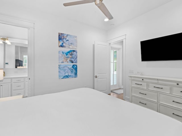 bedroom with ceiling fan, connected bathroom, and light hardwood / wood-style flooring