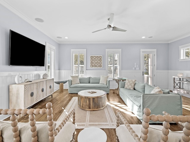 living room with ceiling fan, wood-type flooring, and ornamental molding