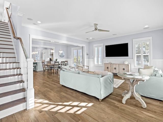 living room with wood-type flooring, ceiling fan, and ornamental molding