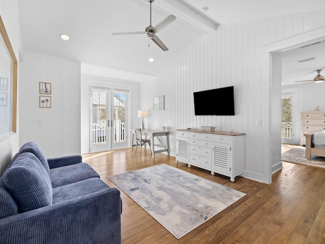 living room featuring ceiling fan, wooden walls, lofted ceiling with beams, and dark hardwood / wood-style floors