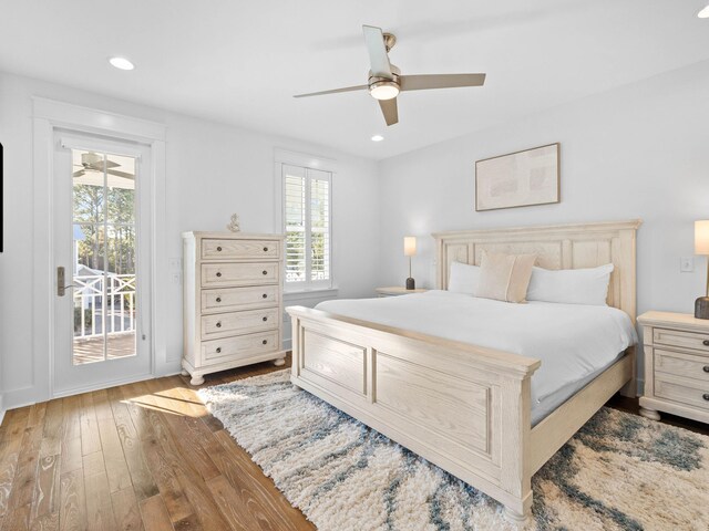 bedroom with access to exterior, wood-type flooring, multiple windows, and ceiling fan