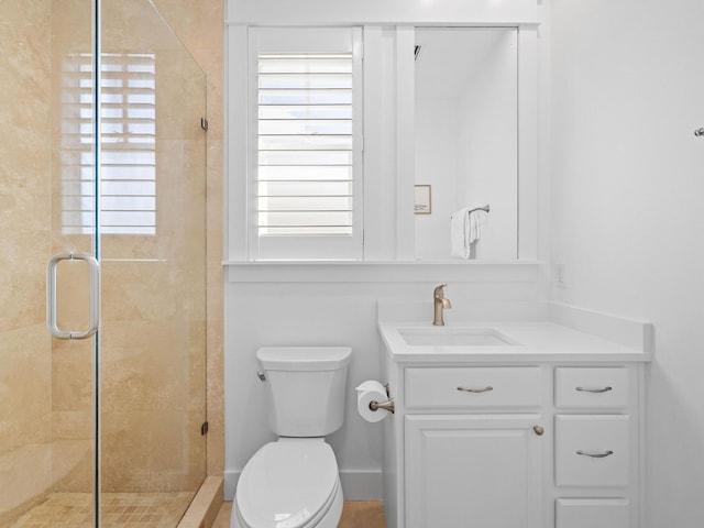 bathroom with vanity, toilet, and a shower with shower door