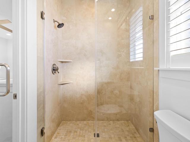 bathroom featuring an enclosed shower and toilet