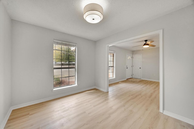 unfurnished room with ceiling fan, a textured ceiling, and light hardwood / wood-style flooring