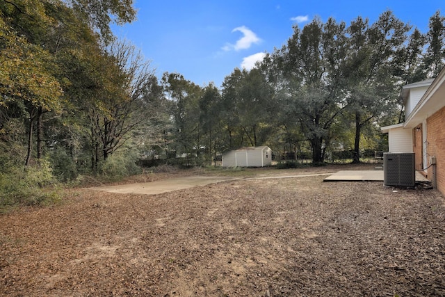 view of yard featuring a shed, central AC unit, and a patio area