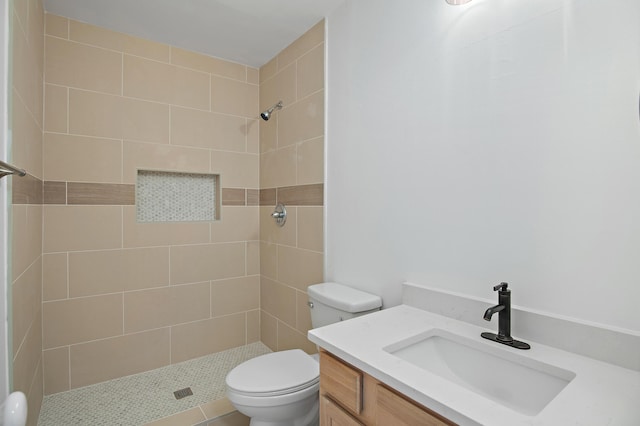 bathroom featuring vanity, toilet, and tiled shower