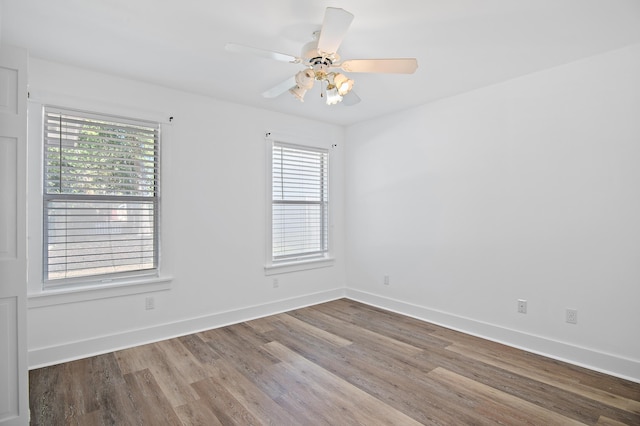 empty room with hardwood / wood-style floors, plenty of natural light, and ceiling fan