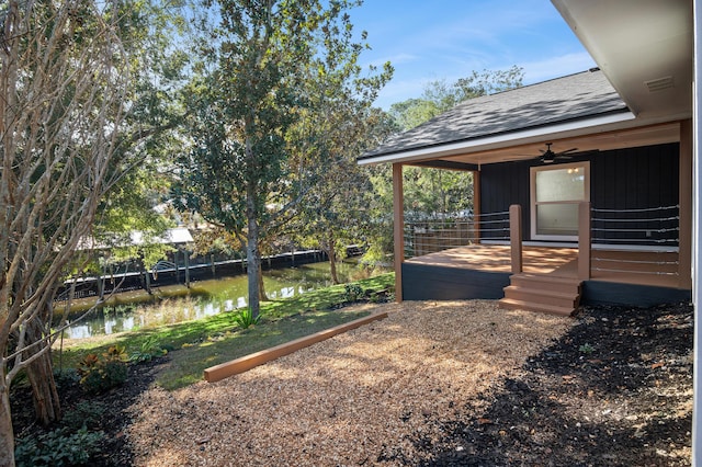 view of yard featuring a water view and ceiling fan