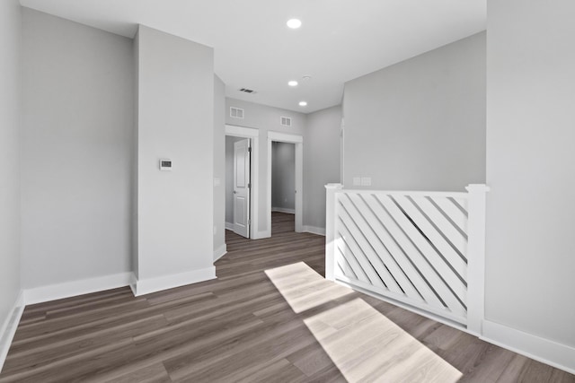 spare room featuring recessed lighting, wood finished floors, and baseboards