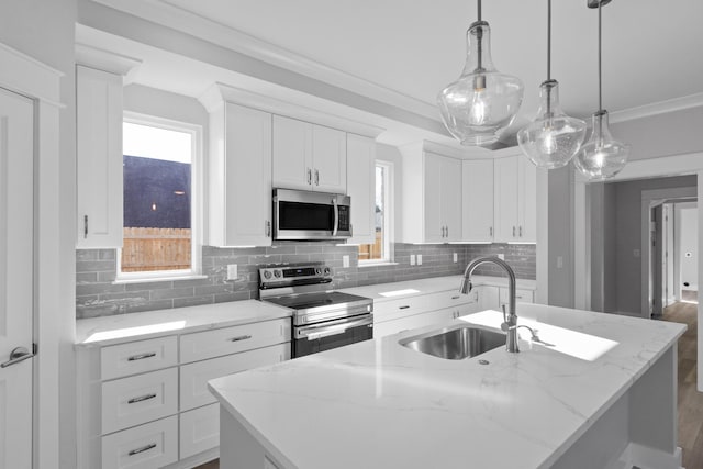 kitchen featuring appliances with stainless steel finishes, a sink, an island with sink, and decorative backsplash