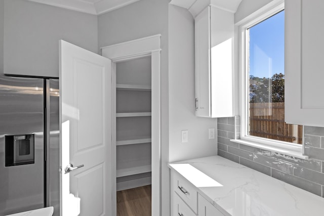 bathroom featuring decorative backsplash, hardwood / wood-style flooring, a wealth of natural light, and ornamental molding