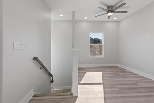 staircase with wood-type flooring and ceiling fan