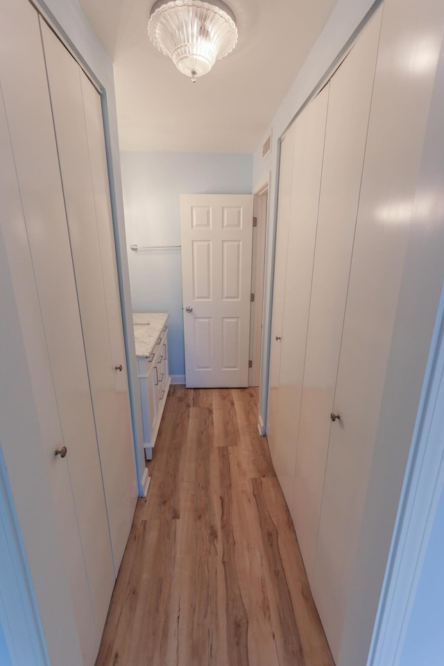 corridor with light hardwood / wood-style floors