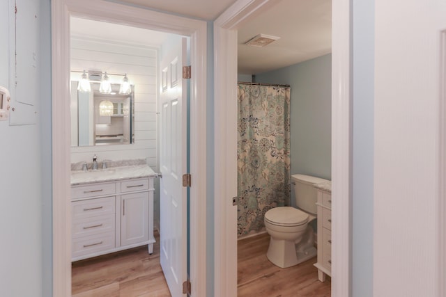 bathroom featuring hardwood / wood-style flooring, vanity, toilet, and a shower with shower curtain