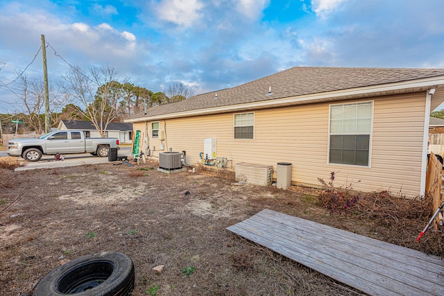 rear view of house featuring central air condition unit