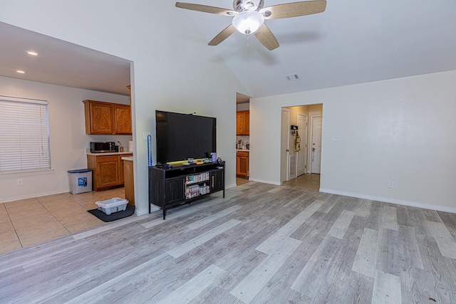 unfurnished living room with ceiling fan, lofted ceiling, and light hardwood / wood-style floors