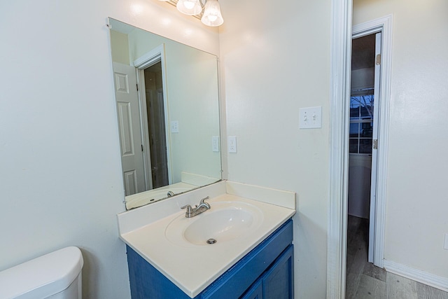 bathroom featuring vanity, hardwood / wood-style floors, and toilet