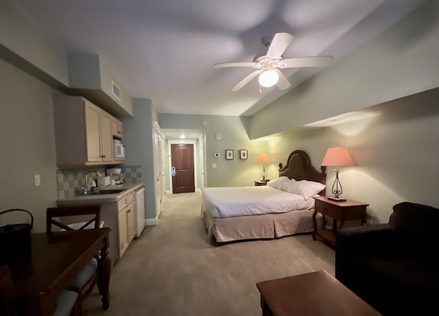 bedroom featuring ceiling fan, light colored carpet, sink, and vaulted ceiling