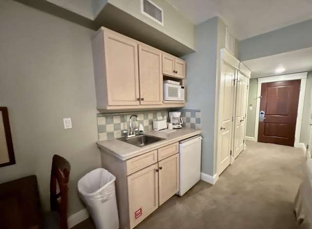 kitchen with tasteful backsplash, sink, light colored carpet, and white appliances