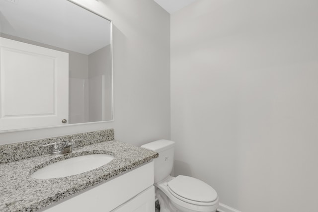 bathroom with walk in shower, vanity, and toilet