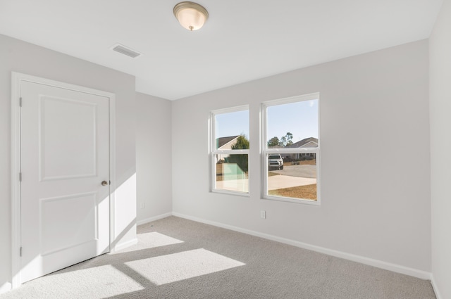 unfurnished room featuring light carpet