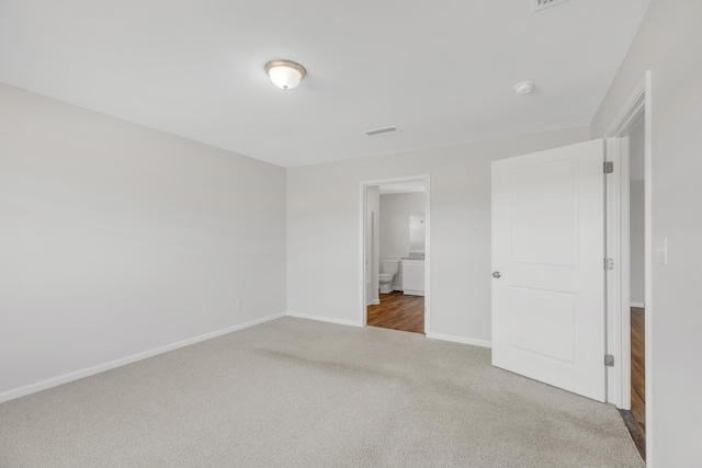 unfurnished bedroom featuring carpet floors and connected bathroom