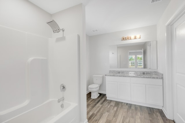 full bathroom featuring hardwood / wood-style floors, vanity,  shower combination, and toilet